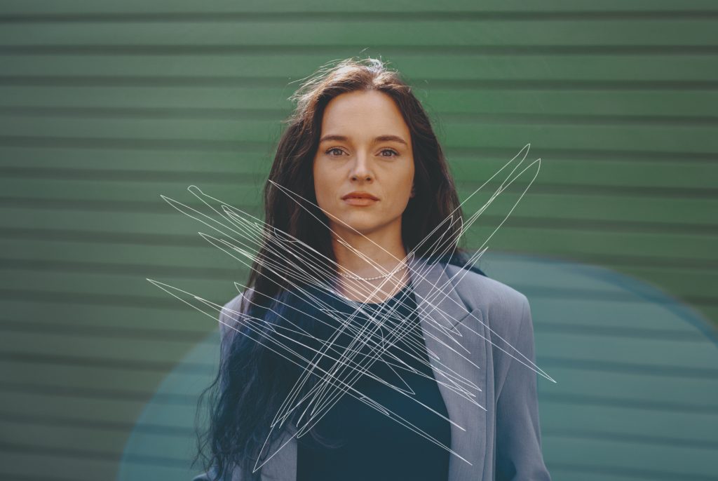 Die Influencerin Josischreibt steht vor einem grünen Hintergrund. Das Foto wurde sichtlich zerkratzt und soll so auf digitale Gewalt aufmerksam machen.