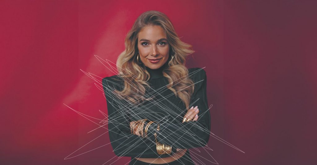 Die Moderatorin Lola Weippert steht vor einem roten Hintergrund. Das Foto wurde sichtlich zerkratzt und soll so auf digitale Gewalt aufmerksam machen.